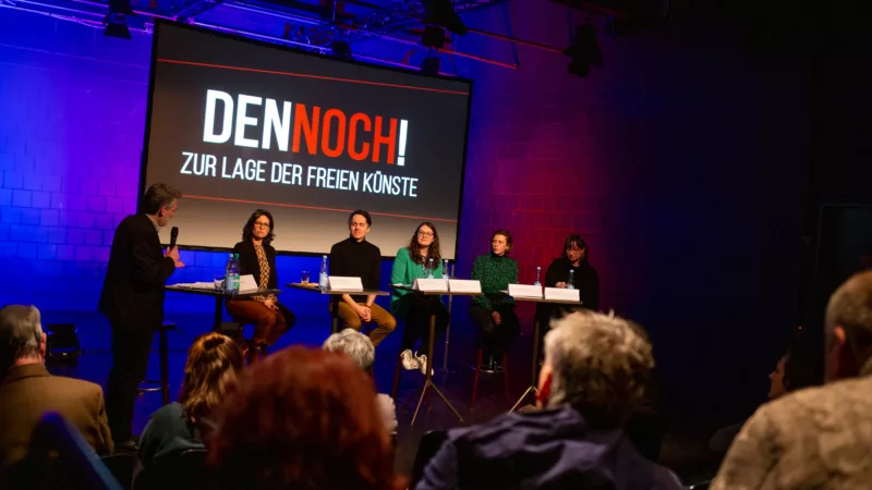 Podiumsgespräch im Pavillon in Hannover. Auf der Bühne sitzen Thomas Kaestle, Nina de la Chevallerie, Sven-Christian Kindler, Antonia Hillberg, Anikó Glogowski-Merten und Sabine Trötschel. Vor ihnen das Publikum. Hinter Ihnen eine Leinwand mit Projektion.