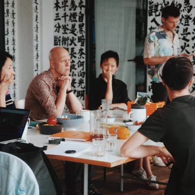 A group of people are sitting around a table having an animated conversation.