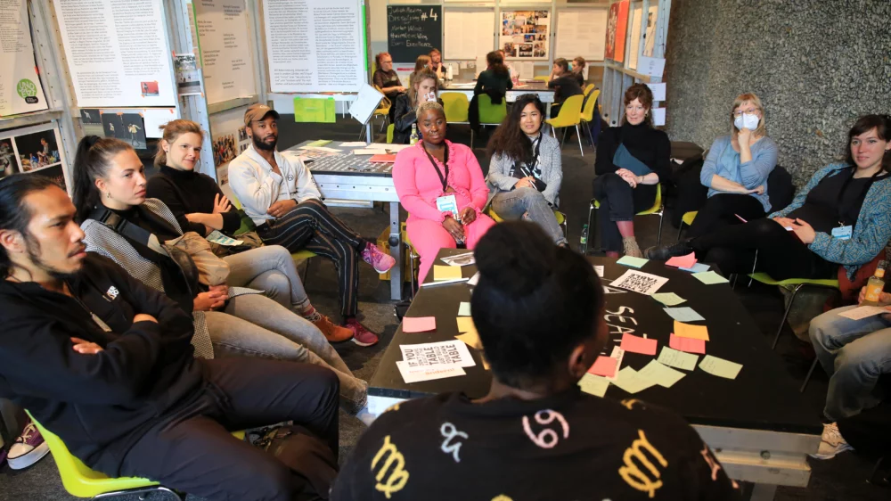 Picture shows a group of people sitting at a table talking at the event