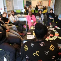 Picture shows a group of people sitting at a table talking at the event