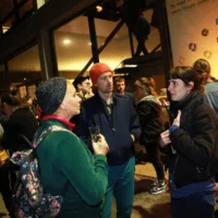 In the evening in front of the Berlin Festspiele groups of people stand engrossed in conversation.