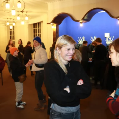 Guests of the film premiere in conversation in the foyer of HAU 1