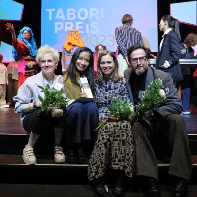 The 2023 award winners sit side by side on the steps of the HAU1 stage: Heinrich Horwitz, Eisa Jocson, Hofmann and Lindholm. In the background, artists from the evening program can still be seen.