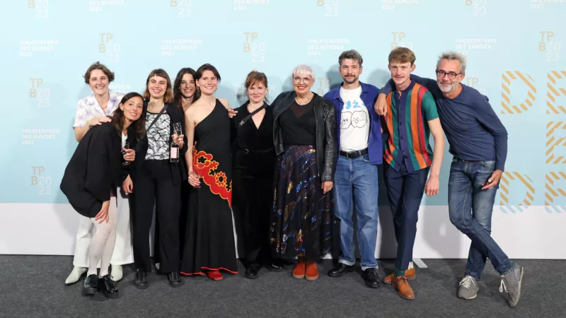 The team of Theaterhaus Jena with Minister of State for Culture Claudia Roth in front of a photo wall